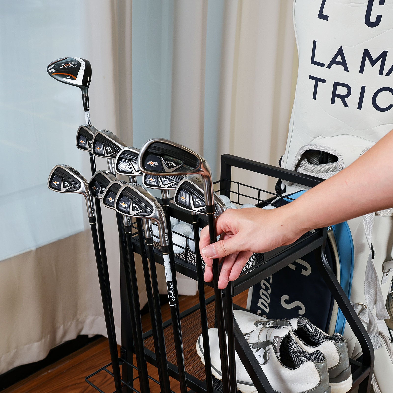 A hand quickly grabbing a golf club from the Finchley golf storage rack, designed for easy and convenient access. 